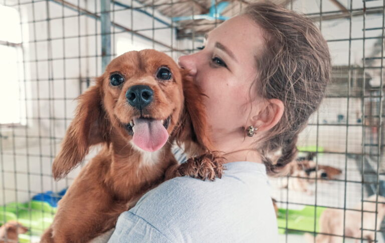 Woman with puppy over shoulder
